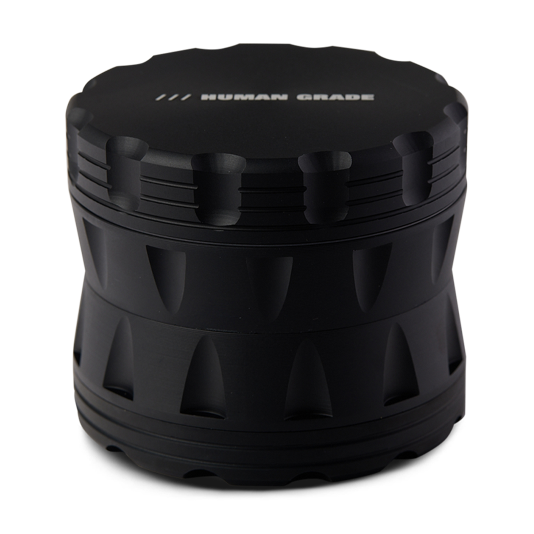 Black herb grinder with 'Human Grade' branding on a white background